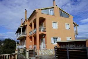 un gran edificio naranja con una valla delante en Marios Family House 2, en Corfú