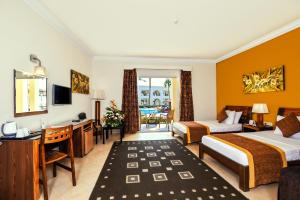 a hotel room with two beds and a desk at Xperience St. George Sharm El Sheikh in Sharm El Sheikh