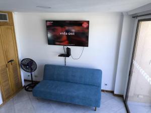 a blue couch in a room with a flat screen tv at Edificio el Penon espectacular vistaa 1503b in Santa Marta