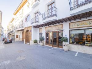 eine Straße in einer Stadt mit Geschäften und Gebäuden in der Unterkunft Cubo's Nueva House Town Center in Alhaurín el Grande