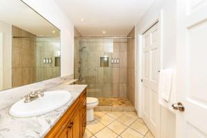 un bagno con lavandino, doccia e WC di 1 Bdrm Pool Garden View at The Yacht Club D3 a Providenciales