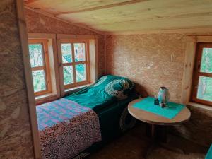 a small room with a bed and a table at Sodyba Pas Juzi in Alanta