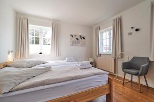a bedroom with a large bed and a chair at Landhaus Markerup in Husby