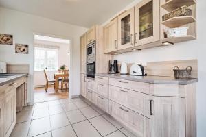a kitchen with wooden cabinets and a counter top at Landhaus Markerup in Husby