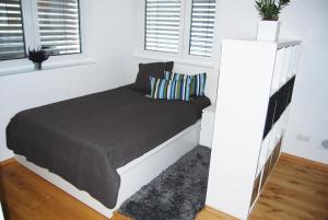 a bed in a white bedroom with windows at Unter der Yburg Stetten in Stetten