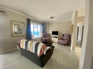 a living room with a couch and two chairs at Watching Waves, Heron Chase in Fish Hoek