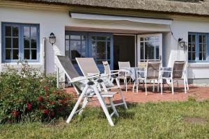 a group of chairs and tables on a patio at Landhaus Markerup - großzügig mit Kamin, Sauna & Spielhaus in Husby