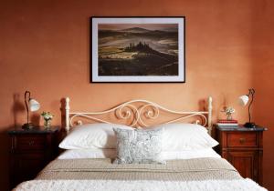 a bedroom with a bed with a picture on the wall at Casa Oliveto in Castelmuzio