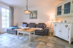 a living room with a couch and a table at Achtern Diek Haus 1a in Zingst