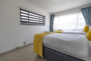 Un dormitorio con dos camas y una ventana. en Safi Classic 3 bedroom Apartment 4, en East London