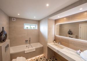 a bathroom with a tub and a large mirror at Scallop Lodge Lytham in Lytham St Annes +6 photos