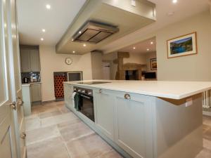 a kitchen with a white counter top and a stove at Tretoil Farm House in Bodmin +37 photos