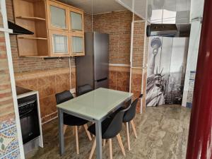 a kitchen with a table and chairs and a refrigerator at Villa Alma in Coslada