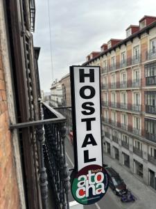 una señal en el costado de un edificio que dice: en Hostal Atocha Almudena Martín, en Madrid
