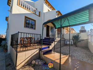 una casa con balcone e tavolo sul patio di Traditional 3 Bed Quad House Playa Flamenca PF5 a Orihuela