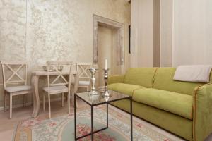 - un salon avec un canapé vert et une table dans l'établissement Apartment Lux Rovinj, à Rovinj