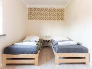 two twin beds in a small room with a table at Noclegi M21 in Białystok