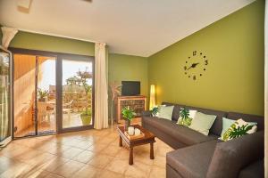 een woonkamer met een bank en een klok aan de muur bij Tropical Casa Verde Santa Maria in Santa Maria
