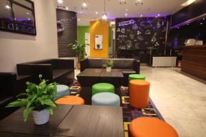 Un restaurante con mesas y sillas verdes y naranjas. en Shanghai Fish Inn Bund, en Shanghái