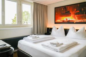 una camera d'albergo con un letto e asciugamani di feRUS Hotel a Lucerna