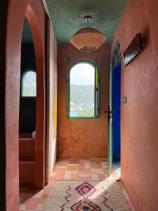 a hallway of a house with a door and a window at Casa Amina in Chefchaouene