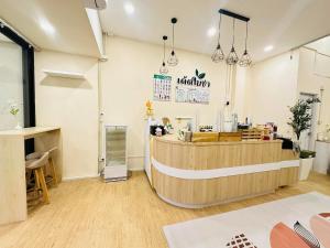 a restaurant with a counter in a room at Dedbaicha cafe & Hostel Phuket old town in Phuket