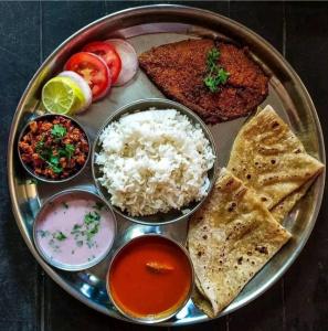 a plate of food with rice and different types of food at Holiday Home Beach Resort And Aquatic Sports In Tarkarli in Malvan
