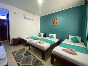 a room with three beds and a green wall at Octopus Hotel in Dahab