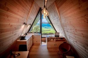 an attic kitchen with a large window and a desk at Sãmo Lodges in Massingy-lès-Vitteaux