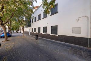 pusta ulica obok białego budynku w obiekcie BF Rooms Almeria Centro w mieście Almería
