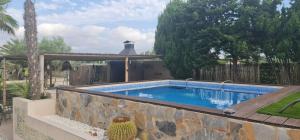 - une piscine dans une cour dotée d'un mur en pierre dans l'établissement Rancho Tropicana, à Alicante