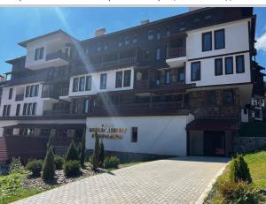 a large white building with a lot of balconies at студио Е 13 in Pamporovo