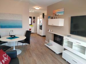 ein Wohnzimmer mit einem Tisch und einem großen TV in der Unterkunft Bahia Sol Deluxe in Caleta de Fuste
