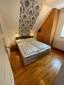 a small bedroom with a bed in a attic at Zámor 10 Apartmant in Keszthely +26 photos