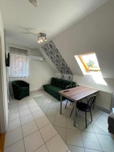 a living room with a green couch and a table at Zámor 10 Apartmant in Keszthely +16 photos