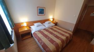 Postel nebo postele na pokoji v ubytování Hotel Baross