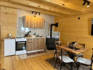 a kitchen with a stove and a table in a cabin at Vista Wood in Žabljak