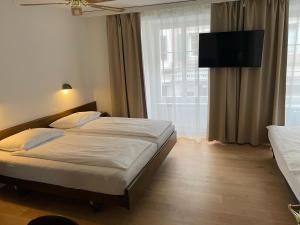 a bedroom with a bed and a large window at ROESLI Guest House in Lucerne +35 photos