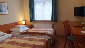 Postel nebo postele na pokoji v ubytování Hotel Baross
