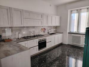 a kitchen with white cabinets and a stove top oven at Casa Cilla Ettore e Anita in Negrar
