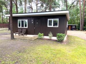 a small cabin with a bench in a yard at California Chalet & Touring Park in Wokingham