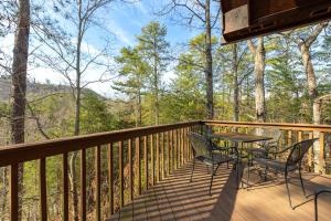 a deck with a table and chairs on it at Bear Hideaway Cozy 3BR Cabin in Sevierville