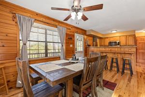 a dining room with a table and chairs and a ceiling fan at Bear Hideaway Cozy 3BR Cabin in Sevierville +37 photos