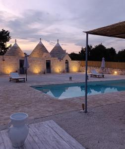 a building with a swimming pool in front of it at Trulli Fortunato private, heated swimming pool in Locorotondo +39 photos