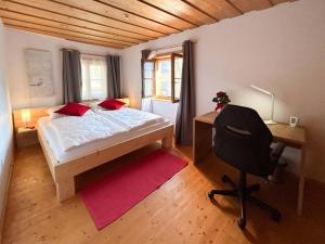 a bedroom with a bed and a desk and a chair at Appartementgitti in Hallstatt