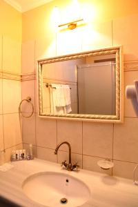 a bathroom with a sink and a mirror at Spon Boutique Hotel in Nafpaktos
