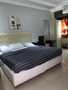 a bedroom with a large bed in a room at Pulville Boulevard Hotel in Surulere +17 photos