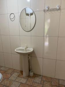 a bathroom with a sink and a mirror at Chalé caiçara aconchegante in Paraty