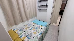 a small bedroom with a bed and a window at Cozy Casa in the City Center in Baguio