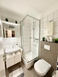 a bathroom with a shower and a toilet and a sink at Gemütliches Apartment mit Blick ins Grüne nähe Messe in Meerbusch